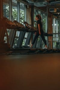 a woman running on a treadmill in a gym