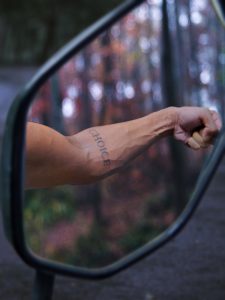 a person's arm is reflected in the side view mirror of a car