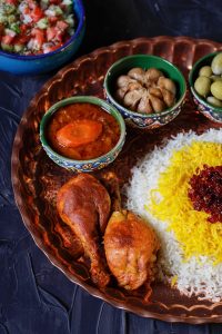 a plate of food with rice, meat, and olives